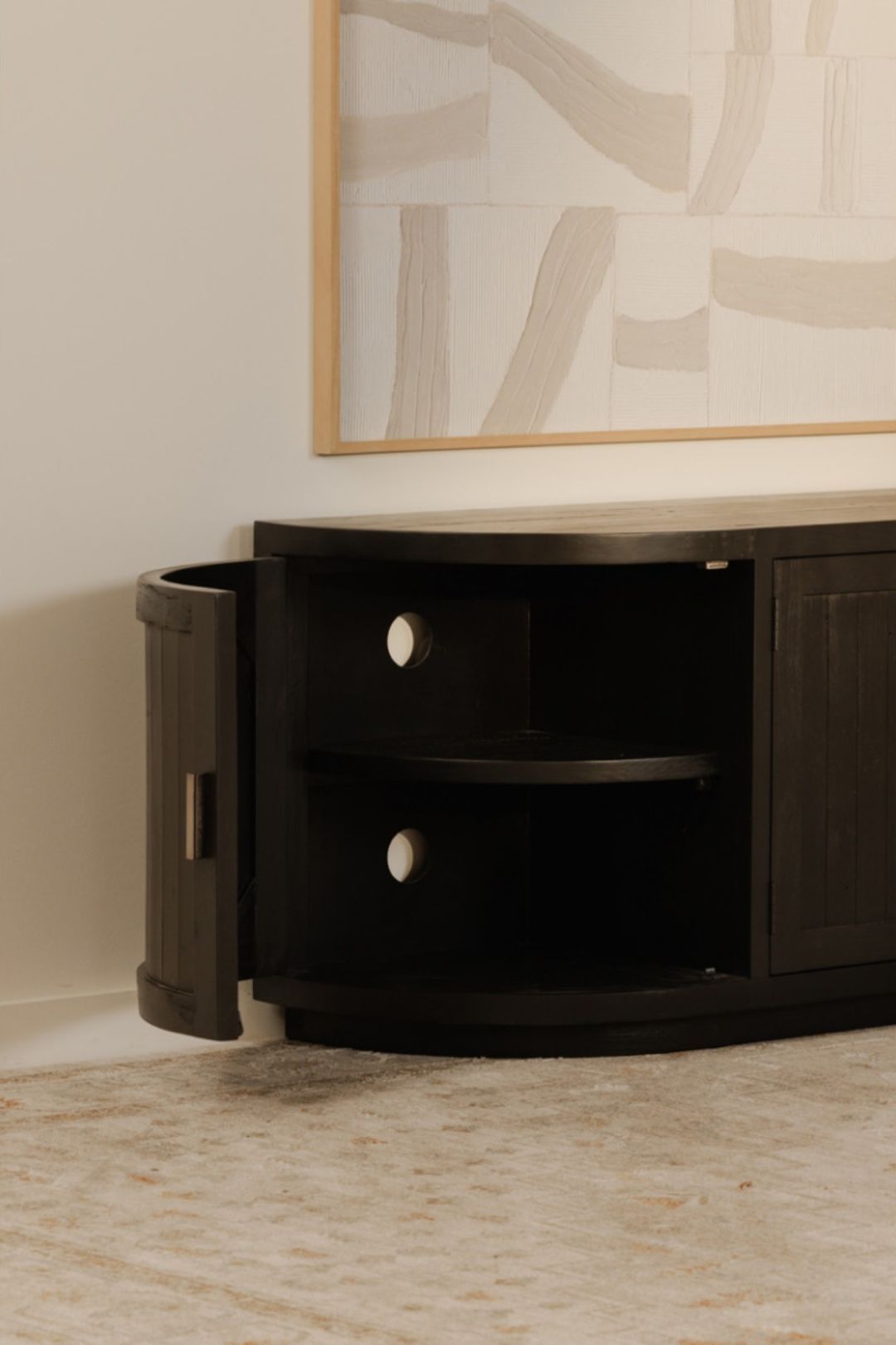 Dark wooden contemporary tv stand with two shelves in a room with an abstract painting on the wall.