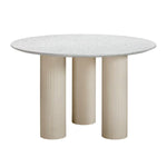 A round dining table with a terrazzo top and fluted legs in a taupe color, designed for both indoor and outdoor use.
