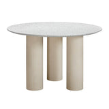 A round dining table with a terrazzo top and fluted legs in a taupe color, designed for both indoor and outdoor use.