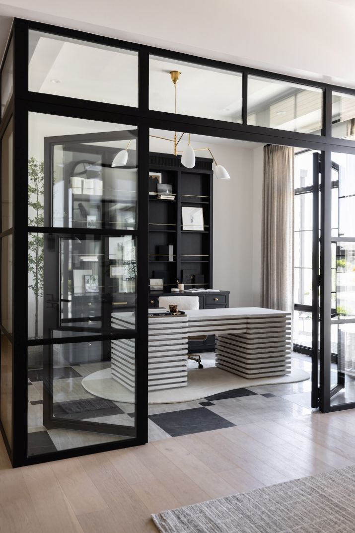 Modern home office workspace with glass walls and a unique wooden white desk.