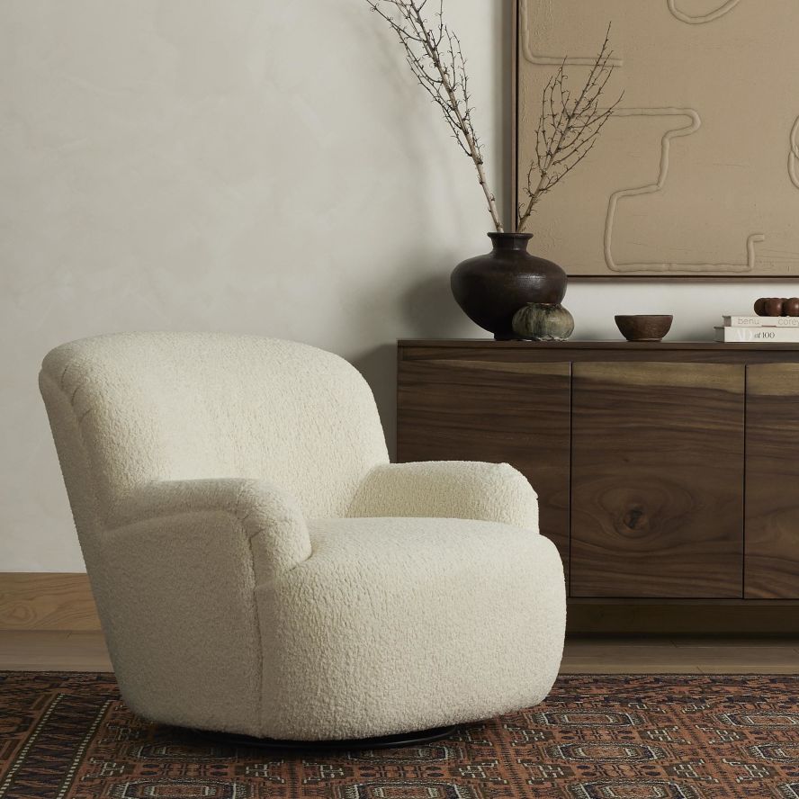 The Kadon Swivel Chair upholstered seating in neutral tones next to a console on a rug
