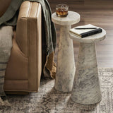 marble nesting tables beside a leather coach with whisky glass and book on them