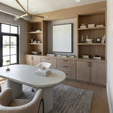 Modern home office with Regina Andrew Talon chandelier, wooden bookshelves, a white desk, and a large window.