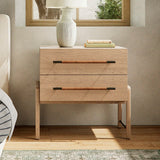 Wooden oak nightstand with two drawers, lamp, and books in a bedroom setting.