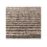 A close-up of a textured woven area rug or mat with horizontal ridges in a heathered beige and brown tone, shown against a white background.